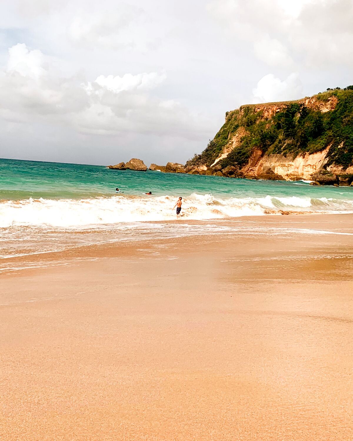 Collecting sea glass in the surf, Puerto Rico